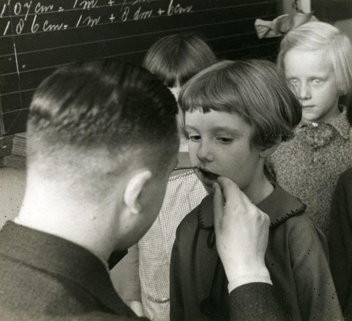 Depistage dentaire scolaire — un dentiste examine les dents d'enfants dans une ecole