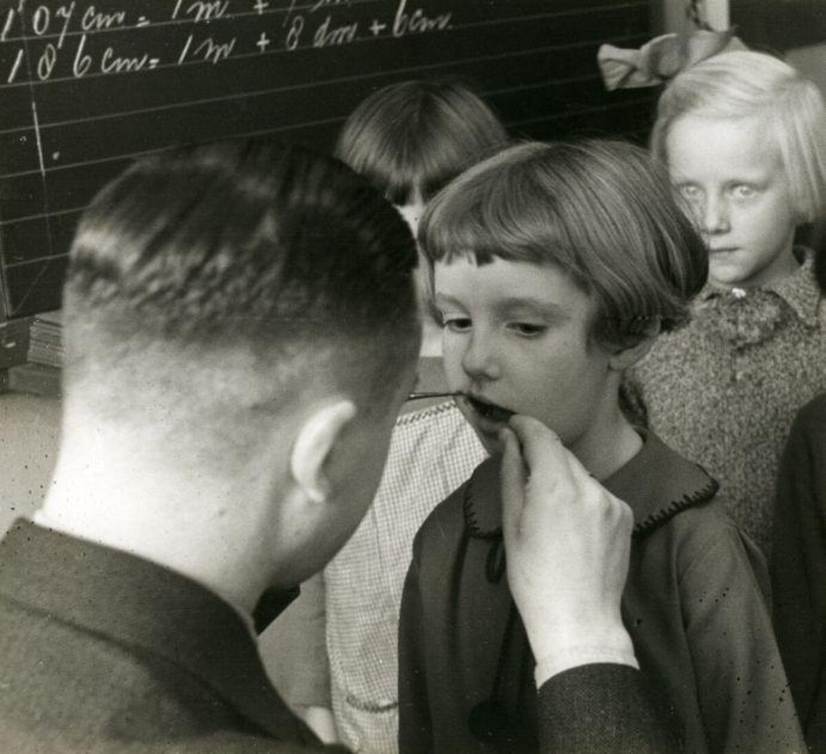 Depistage dentaire scolaire — un dentiste examine les dents d'enfants dans une ecole